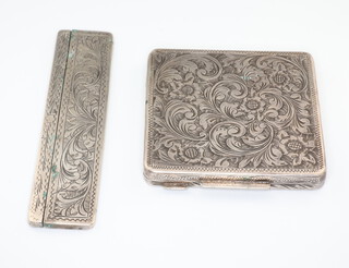 A white metal floral and scroll engraved compact and comb case 