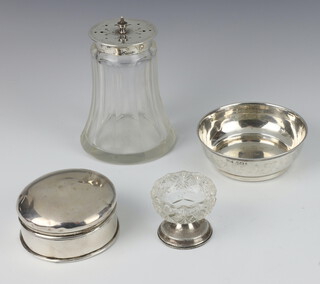An Edwardian glass shaker with pierced silver lid, a shallow dish, circular box and table salt with silver base 106 grams 