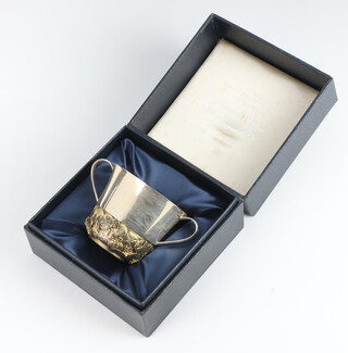 Stuart Devlin, a cast silver and silver gilt commemorative Royal Christening 2 handled porringer Prince William, 4th August 1982, the lower body having cast and chased water lily decoration 146 grams, 6cm, no.166 of 750, London 1982, boxed 