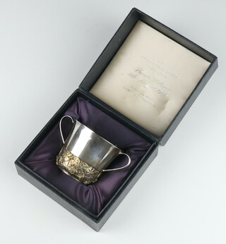 Stuart Devlin, a cast silver and silver gilt commemorative Royal Christening 2 handled porringer Prince William, 4th August 1982, the lower body having cast and chased water lily decoration 152 grams, 6cm, no.76 of 750, London 1982, boxed 