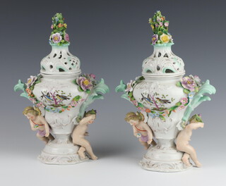 A pair of early 20th Century German porcelain 2 handled vases and covers with floral decoration and cavorting cherubs, with pierced lids 29cm 