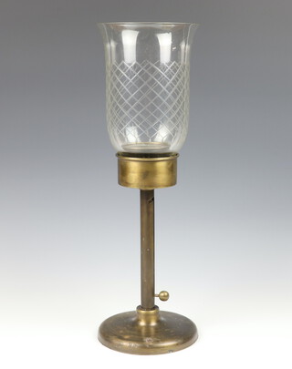 A bronze table lamp with adjustable stem, having a flared cut glass shade 54cm 