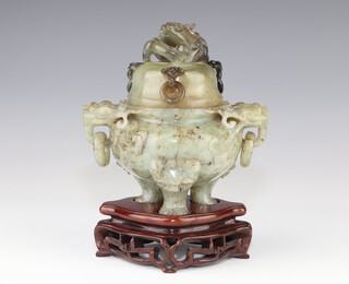 A 20th Century Chinese carved green hardstone squat vase with lion ring handles, lion knees and pad feet, the lid carved with a dragon with drop ring handles on a hardwood stand 15cm, contained in a fitted case