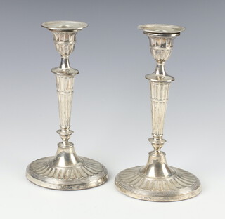 A pair of Edwardian silver oval candlesticks with waisted stems and scallop bases, London 1902, 22cm 