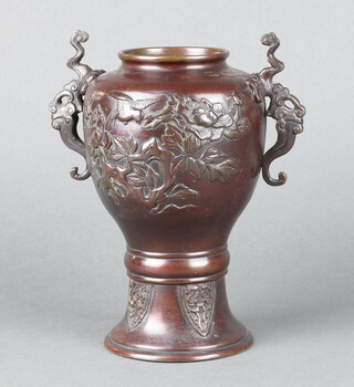 A Japanese bronze twin handled urn, the body decorated birds amidst branches, raised on a shape foot 22cm h x 10cm diam. 