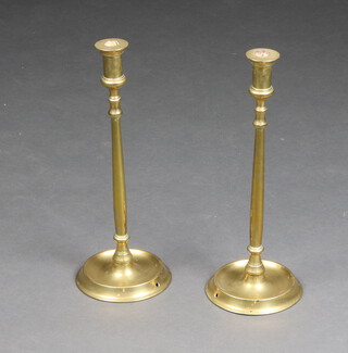 A pair of 19th Century brass candlesticks, raised on circular spreading bases 44cm x 17cm (both feet drilled) 