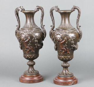 An impressive pair of Victorian spelter twin handled urns, the bodies decorated cherubs raised on turned bases 39cm x 16cm (missing lids) 
