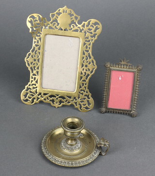 An 18th/19th Century circular gilt metal chamber stick 5cm x 8cm, a pierced brass easel photograph frame 16cm x 20cm, a gilt metal ditto 9cm x 6cm 