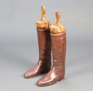 A pair of brown leather riding boots complete with beech trees 