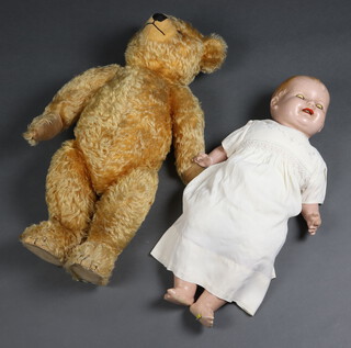 A Mohair teddy bear with articulated limbs 68cm h together with a plastic headed  doll 58cm 