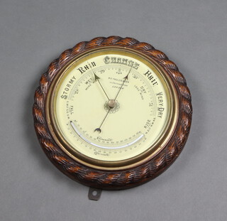 An aneroid barometer the painted dial marked Reynolds and Sons 32 Crutched Friars London, contained in a carved rope edge case 28cm x 5cm 