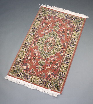 A brown and white ground floral patterned Persia style machine made rug with central medallion 151cm x 91cm 