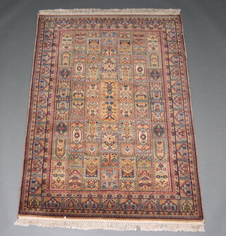 A North West Persian blue and floral pattern rug with 60 rectangular panels to the centre within a multi row border 176cm x 125cm 