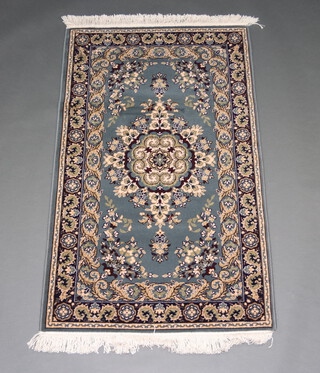 A blue and grey ground Persian style machine made rug with central medallion 149cm x 91cm 