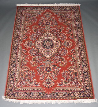 A rust and cream ground Persian style machine made rug with central medallion 242cm x 159cm 