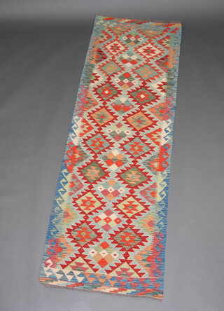 A white, turquoise, blue and green ground Chobi Kilim runner with all over geometric designs 240cm x 78cm 
