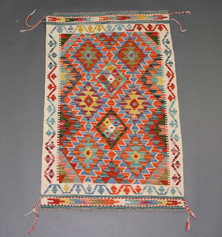 A blue, yellow and white ground Chobi Kilim rug with all over diamond design 130cm x 81cm 
