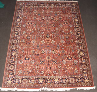 A light brown and blue ground Persian style floral patterned machine made rug 396cm x 300cm 