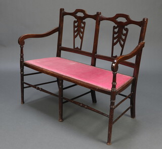 An Edwardian pierced mahogany double chair back settee with upholstered seat raised on turned supports 88cm h x 105cm w x 44cm d (seat 92cm x 32cm) 