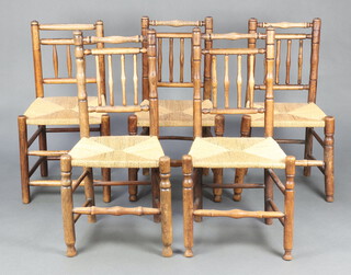 A harlequin set of 5 elm spindle back dining chairs raised on turned supports with woven rush seats comprising 2 pairs and 1 standard (2 x 96cm x 48cm x 38cm, 2 x 98cm x 48cm x 37cm and 1 x 87cm x 46cm x 36cm) 