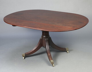 A Georgian oval snap top breakfast table raised on a gun barrel turned column with splayed supports, brass caps and casters 69cm h x 144cm w 106cm d 