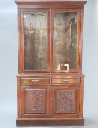 A Victorian carved mahogany bookcase on cabinet, the upper section with moulded cornice, interior fitted adjustable shelves, base fitted 2 long drawers enclosed by a pair of panelled door, raised on a platform base 220cm h x 121cm w x 43cm d  