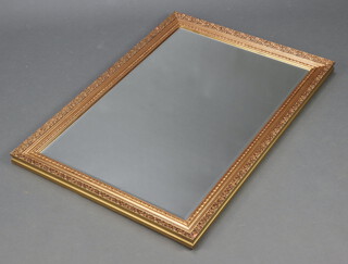 A rectangular bevelled plate mirror contained in a decorative gilt frame 101cm x 70cm 