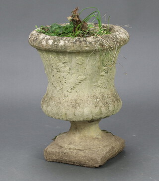 A circular well weathered concrete garden urn with lobed decoration, raised on a square base 43cm h x 34cm diam. (old chip to base) 