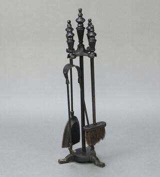 A Victorian style cast iron 4 piece fireside companion set 68cm h 
