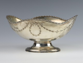 A Georgian style silver boat shaped bowl with engraved decoration raised on a spreading foot, Sheffield 1919, 368 grams 