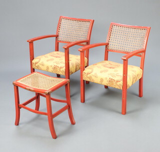 A pair of 1930's Art Deco red lacquered open arm chairs with cane backs and upholstered seats, raised on square supports 75cm h x 53cm w x 51cm d together with a matching stool with woven cane seat, on outswept supports 43cm h x 40cm w x 30cm d 