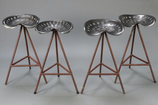 Four mid 20th Century industrial stools, the tops formed from "tractor" seats, raised on tubular metal bases 81cm h x 43cm w x 50cm d (seats 27cm x 25cm)  