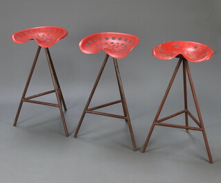 Three mid 20th Century industrial stools, the tops formed from "tractor" seats raised on tubular metal bases 81cm x 43cm x 50cm 