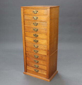 A light oak Wellington chest of 12 drawers with brass swan neck drop handles 114cm h x 48cm w x 34cm d 