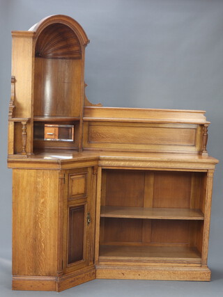 A Victorian carved light oak corner cabinet/bookcase with arched niche above recess fitted a pair of bevelled plate mirror panelled doors, the cupboard beneath having a raised back to the sides and fitted adjustable shelves 202cm x 170cm w x 71cm d 