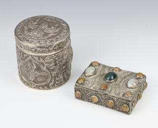 A repousse Sterling silver circular box decorated with figures and having a wooden interior 9cm, together with a white metal hardstone inlaid trinket box  
