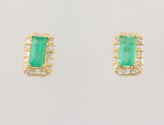 A pair of 18ct yellow gold rectangular emerald and diamond surround ear studs, the emeralds 0.60ct, the diamonds 0.30ct