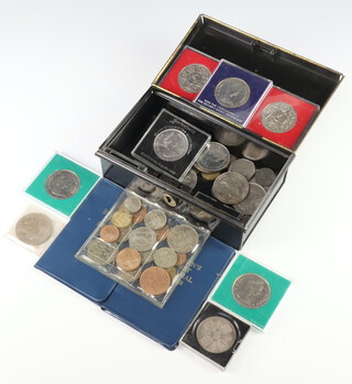 A collection of commemorative crowns contained in a metal cash tin 
