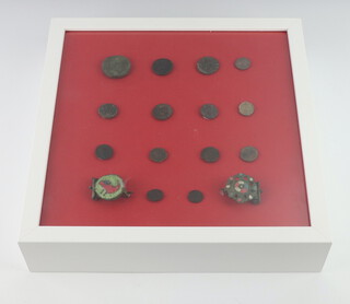 Fourteen various Roman hammered bronze coins together with 2 pierced bronze brooches, framed  