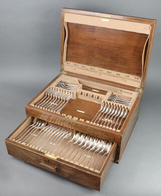 A canteen of silver plated flatware contained in a walnut canteen box comprising 3 table spoons, 9 table forks, 9 soup spoons, 2 ladles, sugar tongs, 9 dessert spoons, 9 dessert forks, 9 tea spoons 