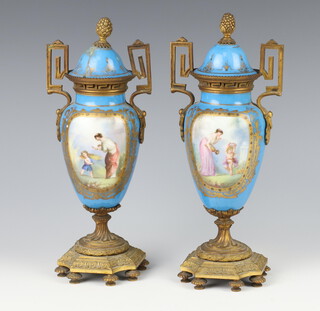 A pair of Sevres style blue ground twin handled vases with panels of figures and gilt metal mounts and finials, raised on gilt metal bases 24cm 