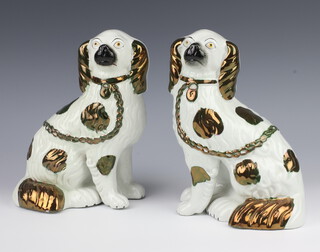 A pair of Victorian Staffordshire spaniels with separate front leg with gilt decoration 22cm 