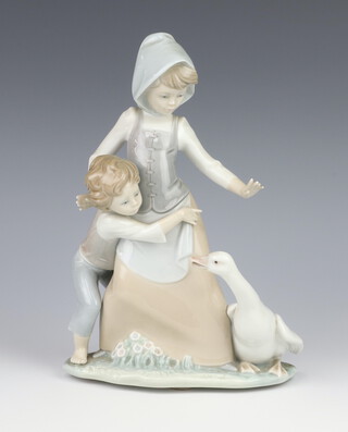 A Lladro group of a lady, boy and goose 24cm 