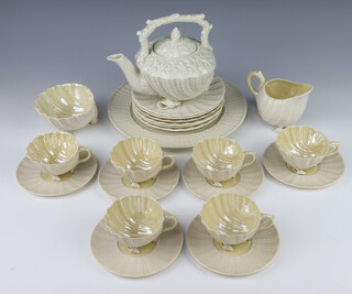 A Belleek tea set of shell form comprising teapot, 6 tea cups, milk jug, sugar bowl, 6 saucers, 6 small plates, 1 large plate, the bases with black mark 