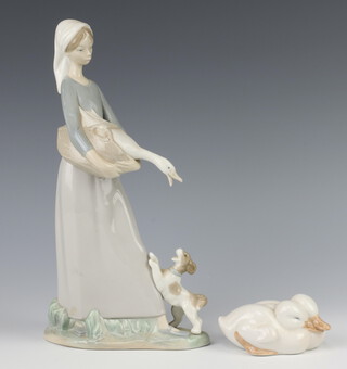 A Lladro figure of a girl holding a goose with a dog at her feet 28cm together with a Royal Copenhagen group of 2 ducks 9cm 