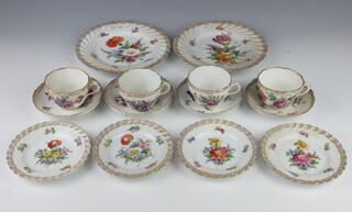 A German porcelain tea set comprising 4 tea cups, 4 saucers (1 riveted), 4 small plates, 2 medium plates, decorated with spring flowers 