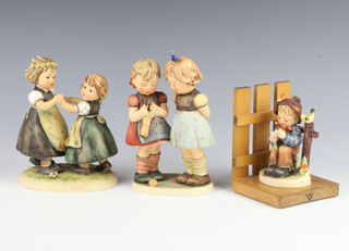 A Hummel group of 2 standing children dancing 353/1 16cm, ditto 2 girls standing 256 18cm and a bookend of a boy with flower 12cm 
