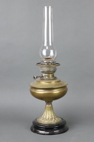 A 19th Century brass oil lamp with ceramic base and clear glass chimney 57cm h x 17cm diam. 