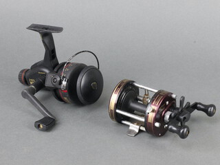 A Shakespeare Neptune fishing reel together with a Mitchell 2165G reel in fibre bag