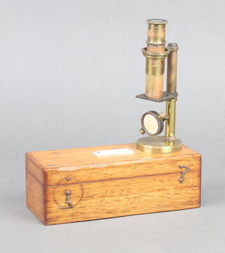 A students 19th Century  gilt metal single pillar microscope 13cm contained in a mahogany box marked Stanley Railway Approach London Bridge 
